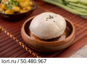 Steamed buns in a wooden dish on a wooden grill. Selective focus. Стоковое фото, агентство Ingram Publishing / Фотобанк Лори