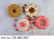 Donuts decorated icing and sprinkles on white background top view. Стоковое фото, агентство Ingram Publishing / Фотобанк Лори