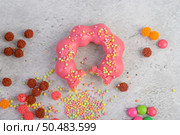 Bitten strawberry donut  decorated icing and sprinkling on the floor. Стоковое фото, агентство Ingram Publishing / Фотобанк Лори