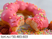 Bitten strawberry donut  decorated icing and sprinkling on the floor. Стоковое фото, агентство Ingram Publishing / Фотобанк Лори