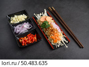 Noodles spicy in Wooden tray with ingredients on black cement background, Selective focus. Стоковое фото, агентство Ingram Publishing / Фотобанк Лори
