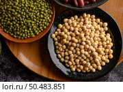 Mung bean and Soy bean on the plate on a black cement floor background. Стоковое фото, агентство Ingram Publishing / Фотобанк Лори