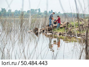 Men and women helped to collect garbage in a black bag. Стоковое фото, агентство Ingram Publishing / Фотобанк Лори