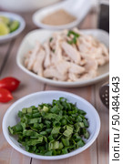 Spring onions and sliced ??Culantro in a white cup on a wooden table. Selective focus. Стоковое фото, агентство Ingram Publishing / Фотобанк Лори