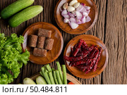 Palm sugar, red onions, dried peppers, tomatoes, cucumbers, yard long beans and lettuce in a bowl. Стоковое фото, агентство Ingram Publishing / Фотобанк Лори