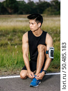 That man laced a shoelace to exercise. Selective focus. Стоковое фото, агентство Ingram Publishing / Фотобанк Лори