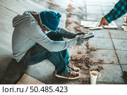 Beggars sitting under the overpass with a credit card and credit card swipe machine. Стоковое фото, агентство Ingram Publishing / Фотобанк Лори