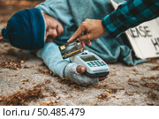 Beggars sitting under the overpass with a credit card and credit card swipe machine. Стоковое фото, агентство Ingram Publishing / Фотобанк Лори