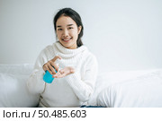 Young women clean their hands with a hand wash gel to prevent germs. Стоковое фото, агентство Ingram Publishing / Фотобанк Лори