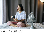 There was a girl sitting and drinking coffee in the bedroom and a pillow on her legs. Стоковое фото, агентство Ingram Publishing / Фотобанк Лори