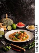 Dry green curry with chicken in white plates on black cement. Стоковое фото, агентство Ingram Publishing / Фотобанк Лори