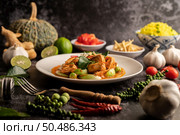 Dry green curry with chicken in white plates on black cement. Стоковое фото, агентство Ingram Publishing / Фотобанк Лори