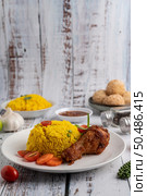 Chicken Biryani in a plate with spices on a white wooden floor. Стоковое фото, агентство Ingram Publishing / Фотобанк Лори