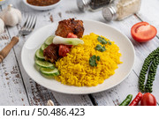 Chicken Biryani in a plate with spices on a white wooden floor. Стоковое фото, агентство Ingram Publishing / Фотобанк Лори