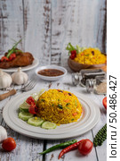Turmeric rice in a white plate with spices on a white wooden floor. Стоковое фото, агентство Ingram Publishing / Фотобанк Лори