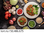 Spicy minced pork salad with chili flakes, lime, chopped green onions, chilli and roasted rice, sliced ??shallots on a cement floor. Стоковое фото, агентство Ingram Publishing / Фотобанк Лори