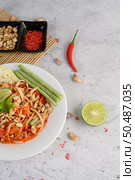 Thai papaya salad in a white plate with chili, lime, dried shrimp, and garlic. Top view. Стоковое фото, агентство Ingram Publishing / Фотобанк Лори