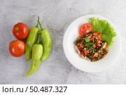Selective focus appetizers with spicy sardine mixed with herb in white tray, green peppers and fresh tomato placed nearly, copy space. Стоковое фото, агентство Ingram Publishing / Фотобанк Лори