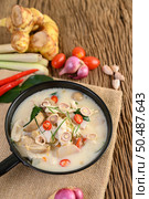 Tom Kha Kai in a pan frying with kaffir lime leaves, lemongrass, red onion, galangal and chilli. Стоковое фото, агентство Ingram Publishing / Фотобанк Лори