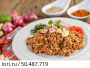 Spicy Minced Pork Salad on a white plate with red onion, lemon grass, garlic, yardlong beans, kaffir lime leaves, and spring onion. Стоковое фото, агентство Ingram Publishing / Фотобанк Лори