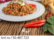 Spicy Minced Pork Salad on a white plate with red onion, lemon grass, garlic, yardlong beans, kaffir lime leaves, and spring onion. Стоковое фото, агентство Ingram Publishing / Фотобанк Лори