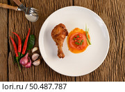 Fried chicken legs on a white plate with sauce and garlic, Shallot, chili. Стоковое фото, агентство Ingram Publishing / Фотобанк Лори