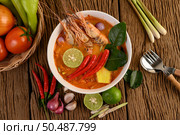 Tom Yum Kung Thai hot spicy soup shrimp with lemon grass,lemon,galangal and chilli on wooden background Thailand Food. Стоковое фото, агентство Ingram Publishing / Фотобанк Лори