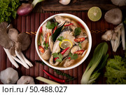 Boil the fish infusion with tomatoes, mushrooms, coriander, spring onion and lemongrass in a bowl. Стоковое фото, агентство Ingram Publishing / Фотобанк Лори