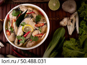 Boil the fish infusion with tomatoes, mushrooms, coriander, spring onion and lemongrass in a bowl. Стоковое фото, агентство Ingram Publishing / Фотобанк Лори