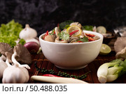 Boil the fish infusion with tomatoes, mushrooms, coriander, spring onion and lemongrass in a bowl. Стоковое фото, агентство Ingram Publishing / Фотобанк Лори