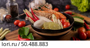 Tom Yum Kung in a bowl with tomato, chili, lemongrass, garlic, lemon, and kaffir lime leaves. Стоковое фото, агентство Ingram Publishing / Фотобанк Лори