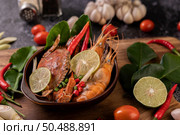 Tom Yum Kung in a bowl with tomato, chili, lemongrass, garlic, lemon, and kaffir lime leaves. Стоковое фото, агентство Ingram Publishing / Фотобанк Лори