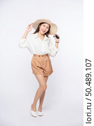 Young woman wearing a white shirt and shorts, wearing a hat and handle on the hat. Стоковое фото, агентство Ingram Publishing / Фотобанк Лори