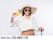 Girl wearing a hat holding credit card and suitcase to travel. Стоковое фото, агентство Ingram Publishing / Фотобанк Лори