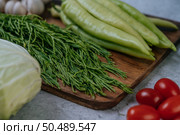 Cha-om, sweet pepper, and garlic on a wooden cutting board. Стоковое фото, агентство Ingram Publishing / Фотобанк Лори