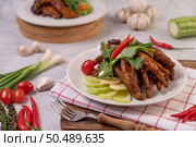 Sweet fried chicken feet in a white plate with coriander, chili, cucumber, and tomato. Стоковое фото, агентство Ingram Publishing / Фотобанк Лори