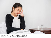 The sick woman had a headache and the hands touched her head on the bed. Стоковое фото, агентство Ingram Publishing / Фотобанк Лори