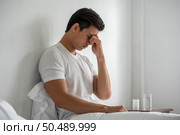 A man with migraines holds her hand by his nose in the bed. Стоковое фото, агентство Ingram Publishing / Фотобанк Лори