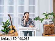 Women sit at the desk and use the phone to coordinate. Стоковое фото, агентство Ingram Publishing / Фотобанк Лори