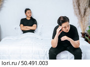A woman who loves each other gets angry and sits on the bed. Стоковое фото, агентство Ingram Publishing / Фотобанк Лори
