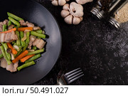 Stir-fried long beans and carrots, add pork belly, put on a black plate. Стоковое фото, агентство Ingram Publishing / Фотобанк Лори