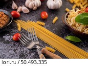 Macaroni sauteed with tomatoes and basil on a gray plate. Стоковое фото, агентство Ingram Publishing / Фотобанк Лори