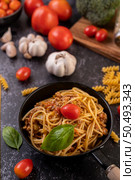 Spaghetti sauteed in a pan-fried with tomatoes and basil. Стоковое фото, агентство Ingram Publishing / Фотобанк Лори