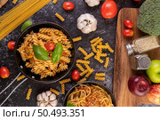 Macaroni sauteed with tomatoes and basil on the pan. Стоковое фото, агентство Ingram Publishing / Фотобанк Лори