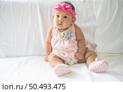A baby learns to sit on a white bed. Стоковое фото, агентство Ingram Publishing / Фотобанк Лори
