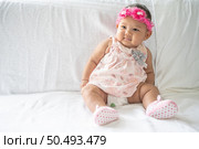 A baby learns to sit on a white bed. Стоковое фото, агентство Ingram Publishing / Фотобанк Лори