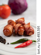 Sausage wrapped pork belly on a white plate. Selective focus. Стоковое фото, агентство Ingram Publishing / Фотобанк Лори