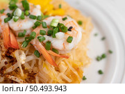 Fresh Pad Thai Shrimp with lime, lettuce, omelet and spring onions in a white plate on wooden. Стоковое фото, агентство Ingram Publishing / Фотобанк Лори