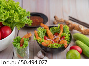 Shrimp deep fried batter placed on salad and tomatoes in a wooden bowl. Стоковое фото, агентство Ingram Publishing / Фотобанк Лори