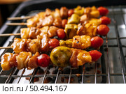 BBQ grill with a variety of meats, complete with tomatoes and bell peppers. Стоковое фото, агентство Ingram Publishing / Фотобанк Лори